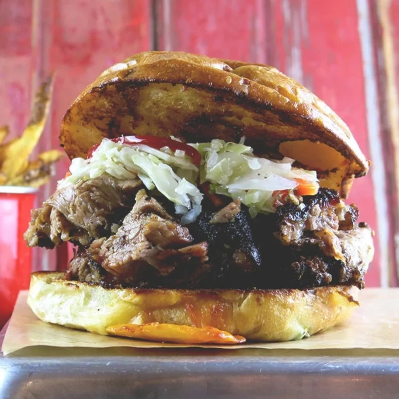 Signature Brisket Sandwich, Marinated Slaw Topper + 1 Side